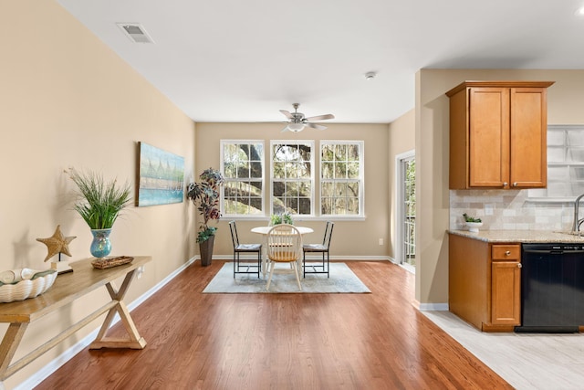 dining area featuring ceiling fan, light wood finished floors, visible vents, and baseboards