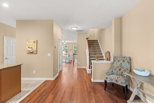 foyer entrance featuring baseboards, stairway, visible vents, and light wood-style floors