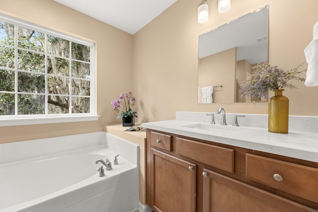 full bath with vanity, a bath, and a healthy amount of sunlight