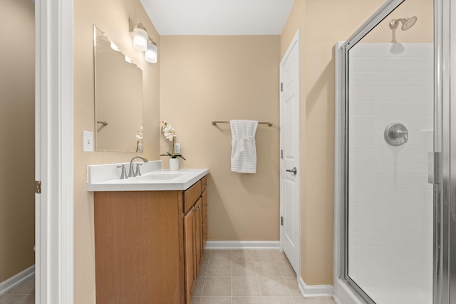 bathroom with a stall shower, vanity, baseboards, and tile patterned floors