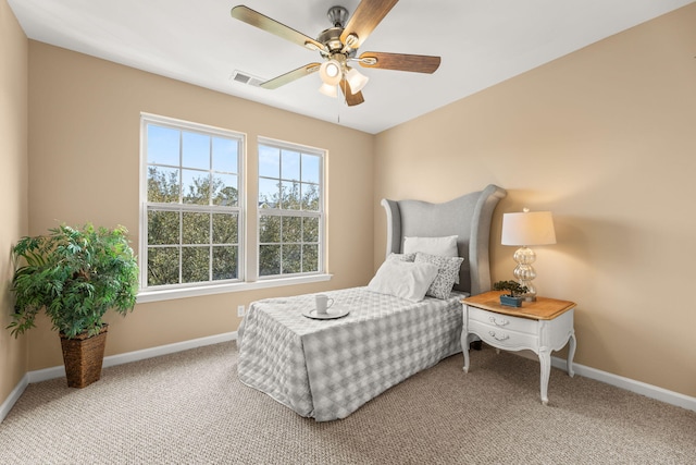 bedroom with a ceiling fan, light colored carpet, visible vents, and baseboards