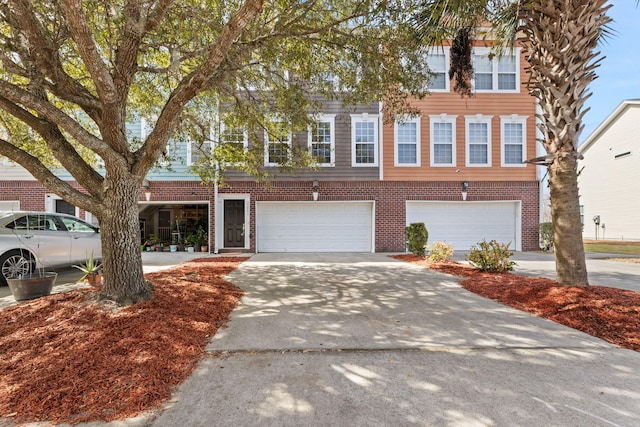 view of property featuring a garage, concrete driveway, and brick siding