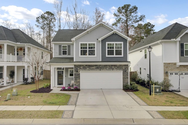 view of front facade with stone siding, an attached garage, driveway, and a front yard