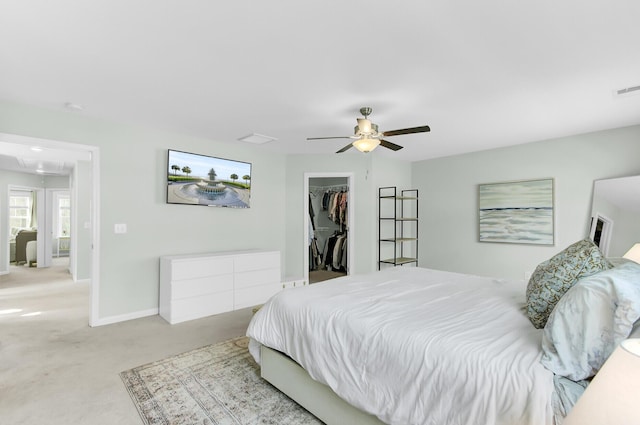 bedroom featuring baseboards, attic access, ceiling fan, a spacious closet, and carpet flooring