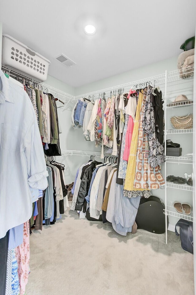 walk in closet featuring visible vents and carpet