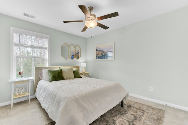 carpeted bedroom featuring visible vents, baseboards, and a ceiling fan