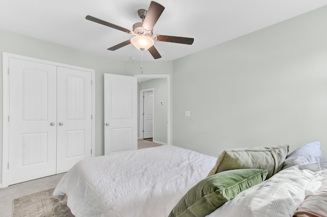 bedroom featuring a closet, light colored carpet, and ceiling fan