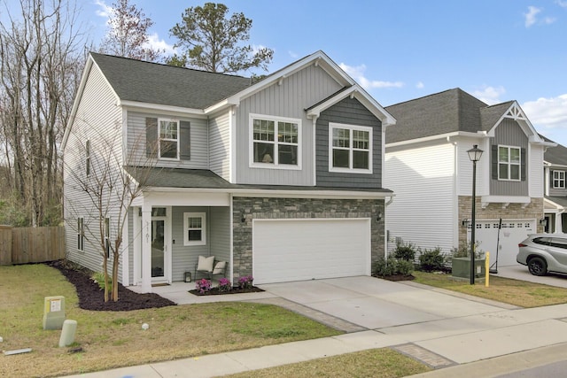 view of front of house with concrete driveway, an attached garage, fence, and stone siding