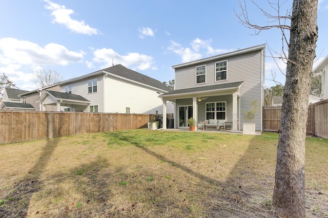 back of property featuring a patio, a lawn, a fenced backyard, and a ceiling fan