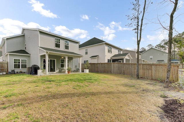 rear view of house featuring a patio, fence, and a lawn