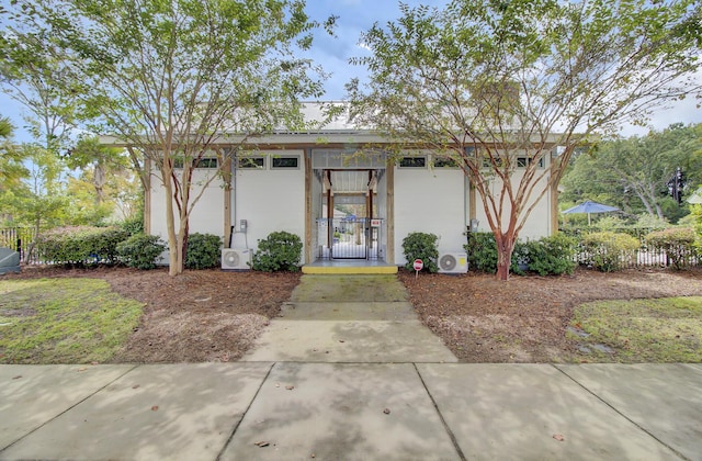 view of front of home featuring stucco siding and fence