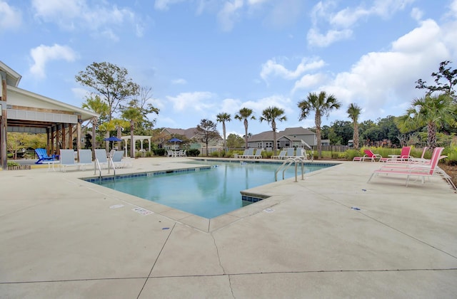 pool with a patio area and fence