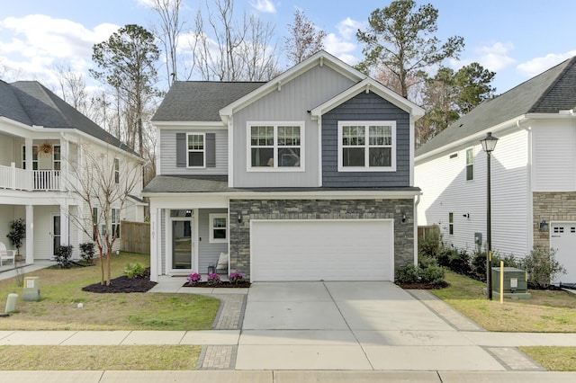 view of front of property with a front lawn, stone siding, central AC, concrete driveway, and a garage