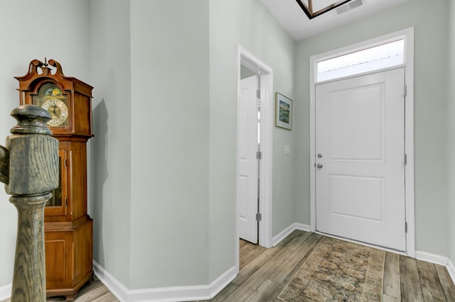 foyer with visible vents, baseboards, and light wood-style flooring