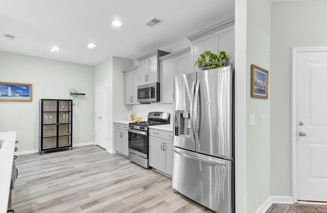 kitchen featuring visible vents, gray cabinets, light wood-style floors, appliances with stainless steel finishes, and light countertops