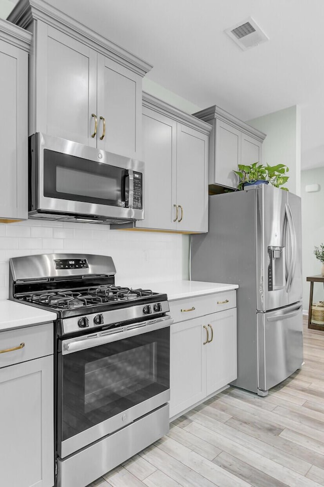 kitchen featuring decorative backsplash, light countertops, visible vents, and appliances with stainless steel finishes