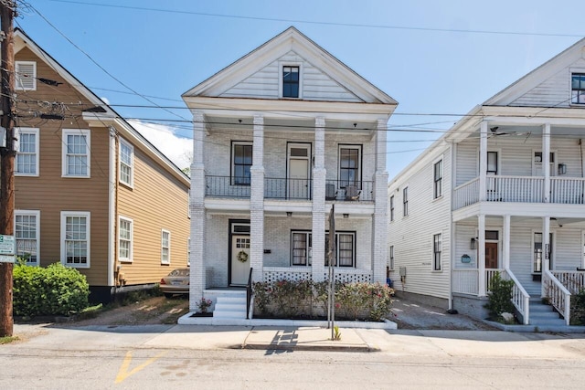 view of front of home featuring a porch, a balcony, and brick siding