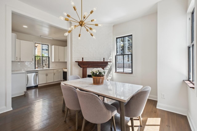 dining area with a healthy amount of sunlight, baseboards, dark wood-style floors, and a notable chandelier