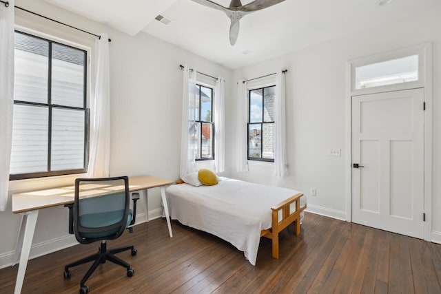 bedroom with visible vents, baseboards, dark wood-type flooring, and ceiling fan
