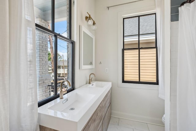 bathroom with baseboards, a sink, marble finish floor, and toilet