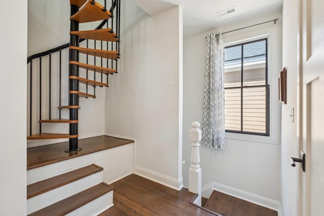 stairway featuring visible vents, baseboards, and wood finished floors