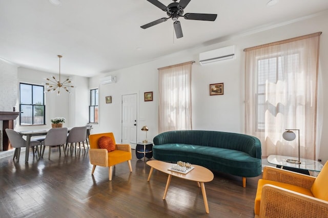 living area with a wall unit AC, ceiling fan with notable chandelier, a wall mounted air conditioner, and wood finished floors