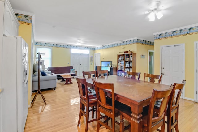 dining space featuring light wood-style floors and ornamental molding