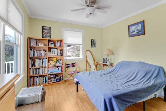 bedroom featuring multiple windows, crown molding, and wood finished floors