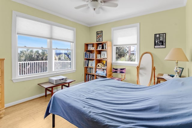 bedroom featuring a ceiling fan, crown molding, wood finished floors, and baseboards