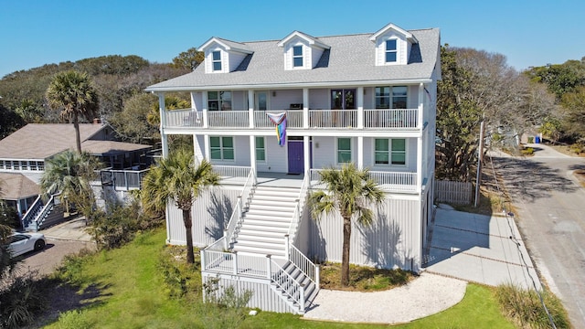 view of front of house featuring a balcony, a porch, and stairs