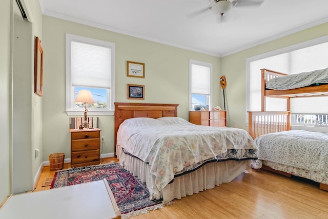 bedroom featuring crown molding, wood finished floors, and baseboards