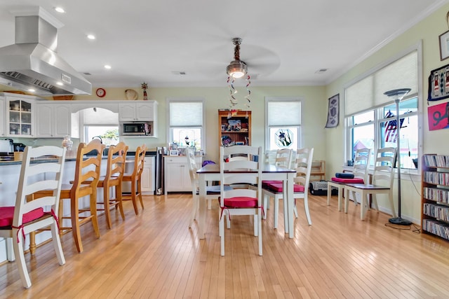 dining area featuring recessed lighting, a healthy amount of sunlight, light wood-style flooring, and crown molding