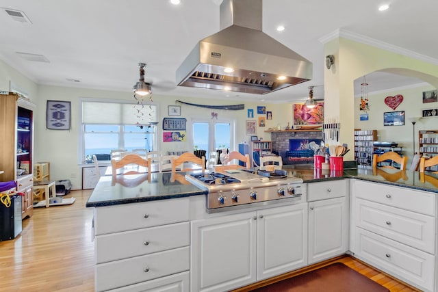 kitchen featuring visible vents, extractor fan, stainless steel gas cooktop, a peninsula, and plenty of natural light