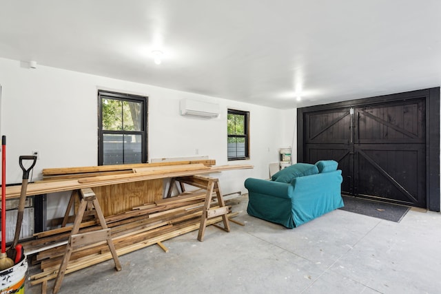 living room with concrete flooring, plenty of natural light, and a wall unit AC