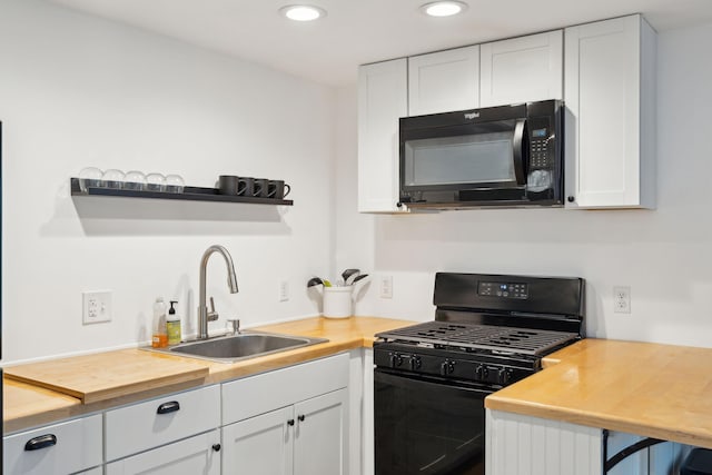 kitchen with white cabinets, wood counters, sink, and black appliances