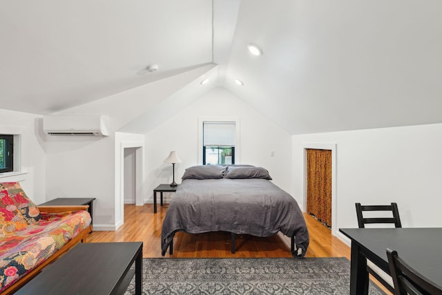 bedroom featuring vaulted ceiling, wood-type flooring, and a wall unit AC