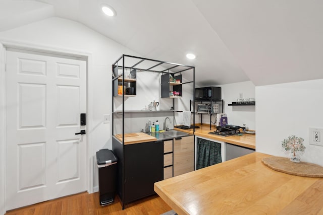 kitchen featuring lofted ceiling, sink, and wood-type flooring