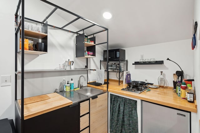 kitchen with wood counters, sink, and stainless steel gas stovetop