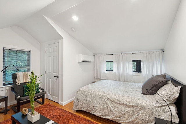 bedroom with lofted ceiling, wood-type flooring, and a wall unit AC