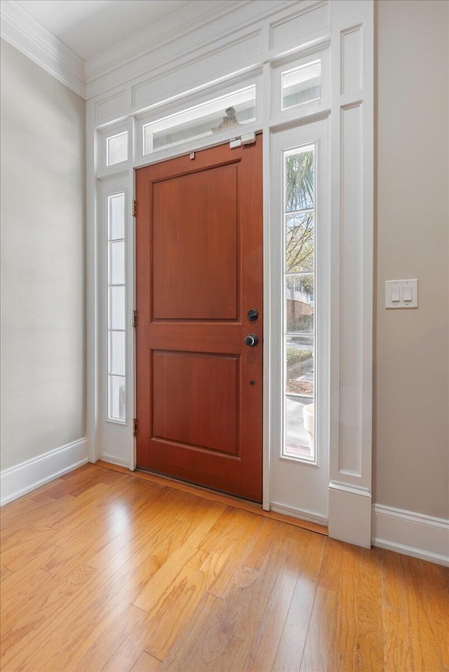 entryway featuring crown molding and light hardwood / wood-style flooring