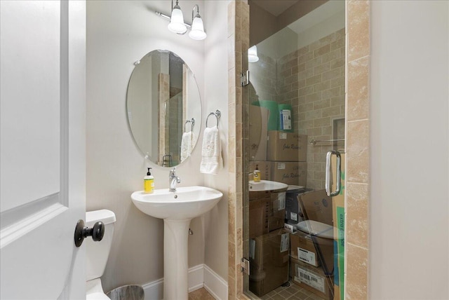 bathroom featuring a shower with shower door and sink