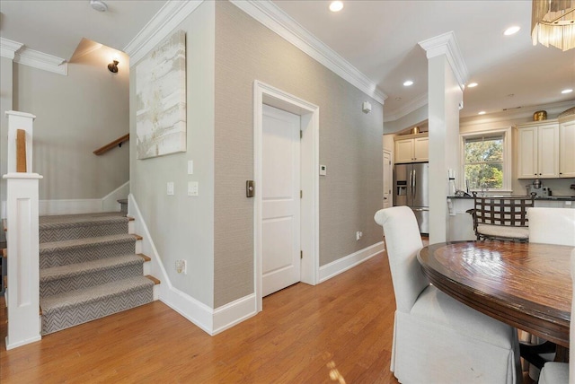 dining area featuring crown molding and light wood-type flooring