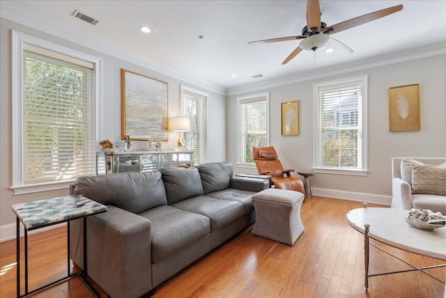 living room with ceiling fan, ornamental molding, and light hardwood / wood-style flooring