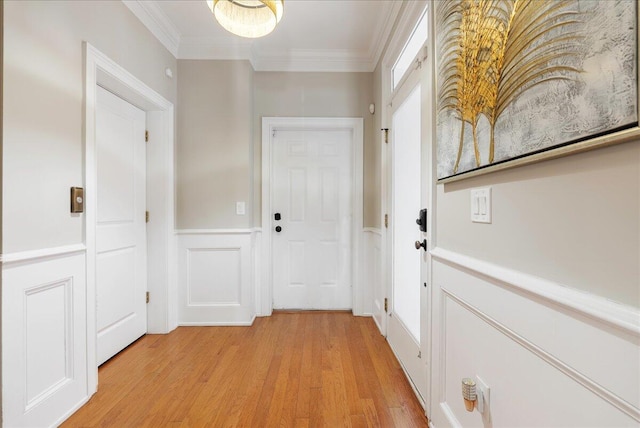 doorway with ornamental molding and light hardwood / wood-style floors