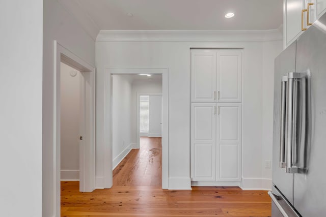 corridor with recessed lighting, light wood-type flooring, baseboards, and ornamental molding