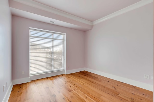 empty room featuring baseboards, wood-type flooring, and ornamental molding