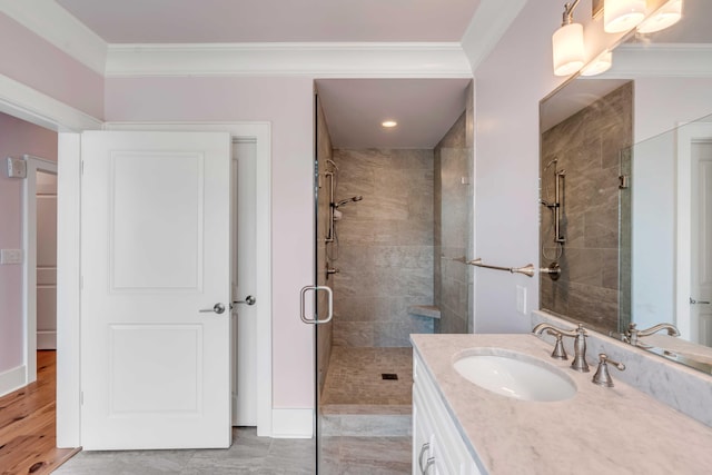 bathroom featuring vanity, a stall shower, and ornamental molding