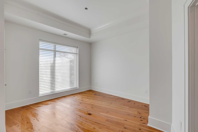 empty room featuring light wood-style flooring, visible vents, and baseboards