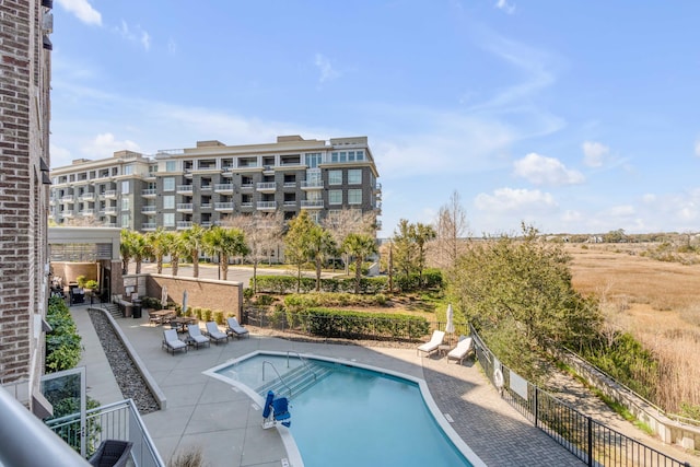 pool with a patio area and fence