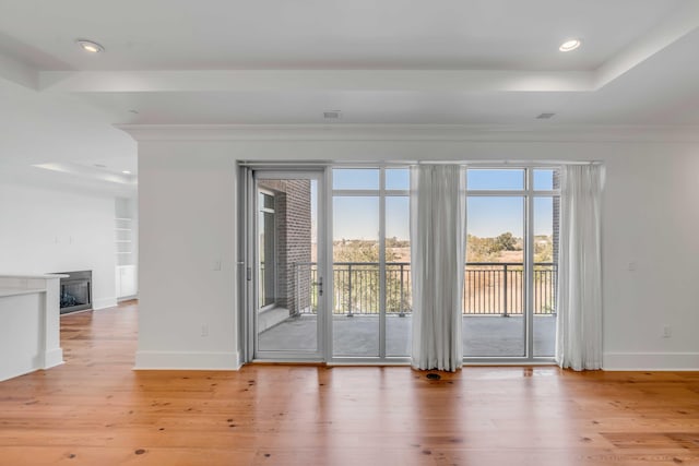 empty room featuring a fireplace, recessed lighting, wood finished floors, and baseboards